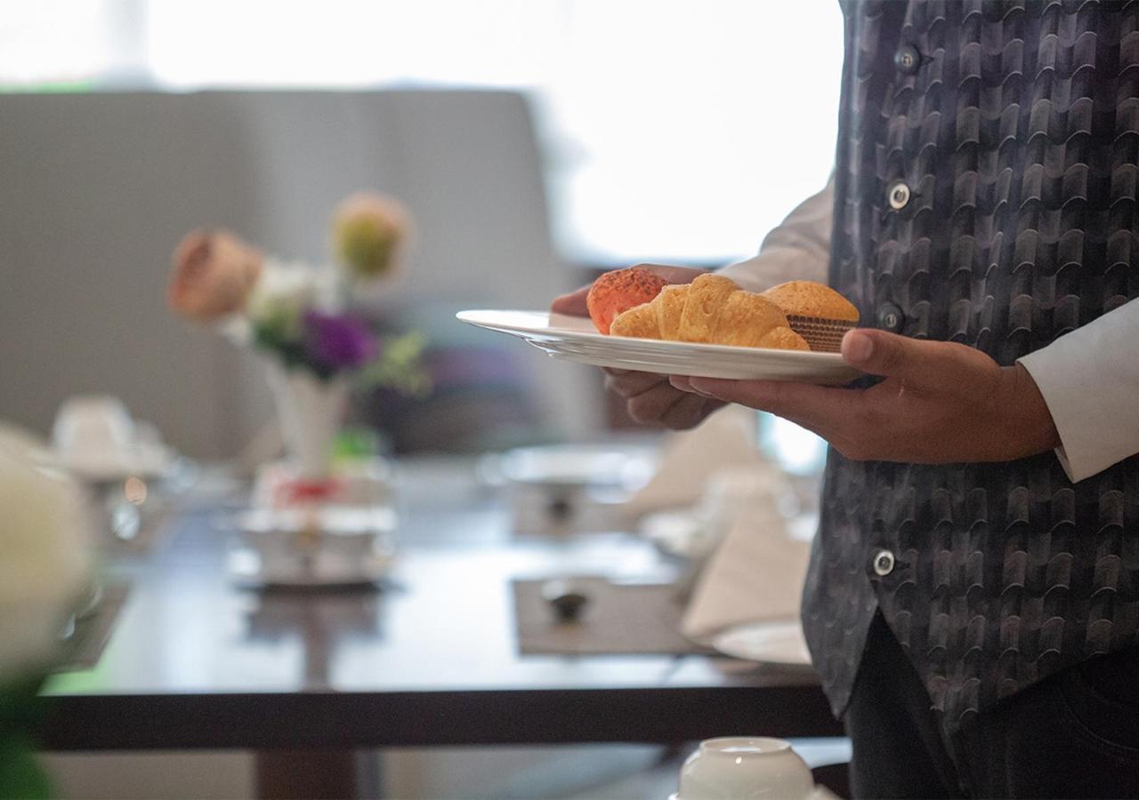 Holiday Suites Al Azizia Mecca Екстер'єр фото A waiter serving food at a buffet